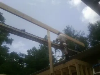 Carpenter setting a ridge beam over a new addition frame — Ice Dam Removal by Roofing Brothers in Edelstein